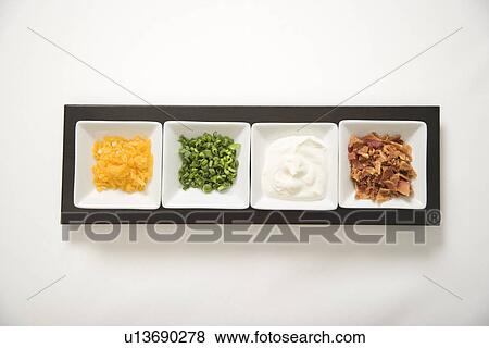 Baked potato side dishes filled with cheese, scallion onions, sour cream, and bacon. View Large Photo Image Stock Photo - Baked potato side dishes filled with cheese, scallion onions, sour cream, and bacon.. Fotosearch