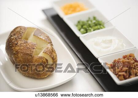 Baked potato sliced down the middle with several toppings. View Large Photo Image Stock Photograph - Baked potato sliced down the middle with several toppings.. Fotosearch
