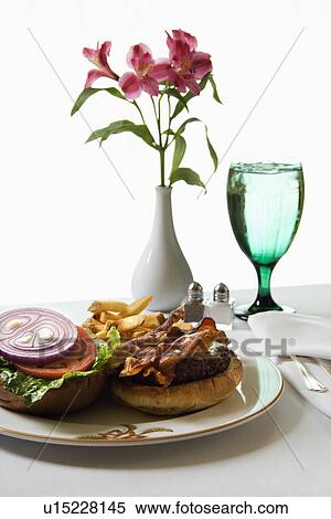 Cheeseburger meal with flowers and glass of water. View Large Photo Image Stock Photography - Cheeseburger meal with flowers and glass of water.. Fotosearch