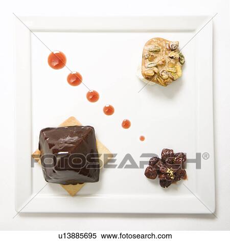 Stock Photography - Chocolate cheesecake pyramid with dried cherries and pistachio praline.. Fotosearch