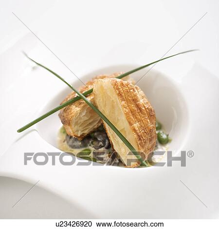 Stock Image - Escargot en croute with butter and fava beans.. Fotosearch