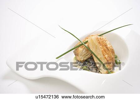 Stock Photograph - Escargot en croute with butter and fava beans.. Fotosearch