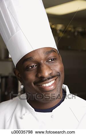 Stock Photo - Head shot of smiling African-American male chef wearing traditional uniform and toque.. Fotosearch