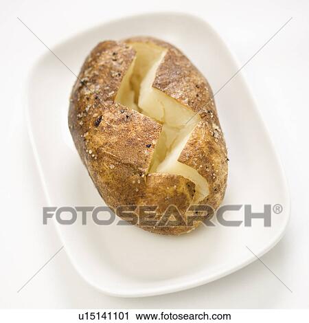Stock Image - Plain baked potato sliced down the middle on a plate.. Fotosearch