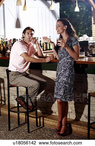 Couple in a bar, man smoking cigar View Large Photo Image Stock Image - Couple in a bar, man smoking cigar. Fotosearch