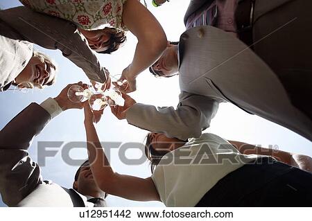 Stock Image - Group of people with champagne glasses toasting. Fotosearch