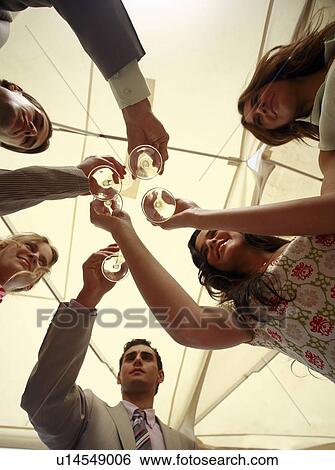 Stock Photograph - Group of people with champagne glasses toasting. Fotosearch