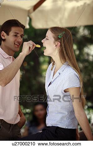 Man feeding woman a potato chip View Large Photo Image Stock Image - Man feeding woman a potato chip. Fotosearch