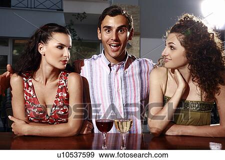 Two women and man in a bar View Large Photo Image Stock Photo - Two women and man in a bar. Fotosearch