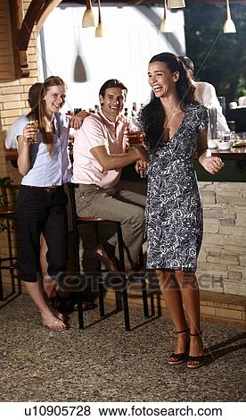 Stock Photo - Two women and man in a bar. Fotosearch