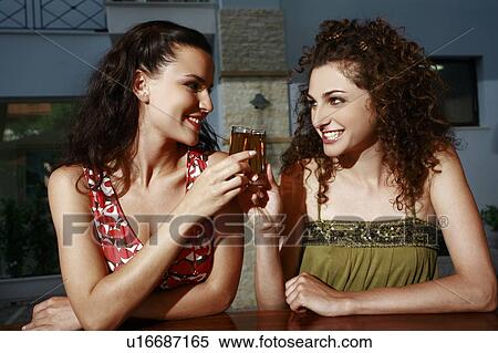 Two women in a bar toasting with shots View Large Photo Image Stock Photography - Two women in a bar toasting with shots. Fotosearch