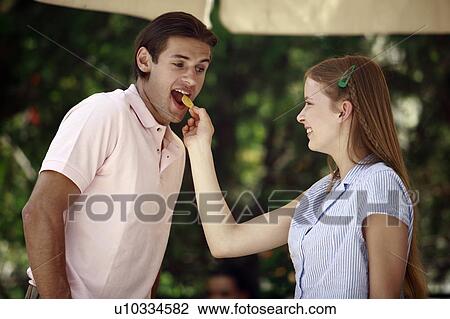 Woman feeding man a potato chip View Large Photo Image Stock Image - Woman feeding man a potato chip. Fotosearch