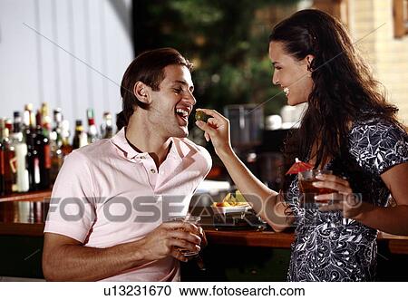 Woman feeding man in a bar View Large Photo Image Stock Image - Woman feeding man in a bar. Fotosearch