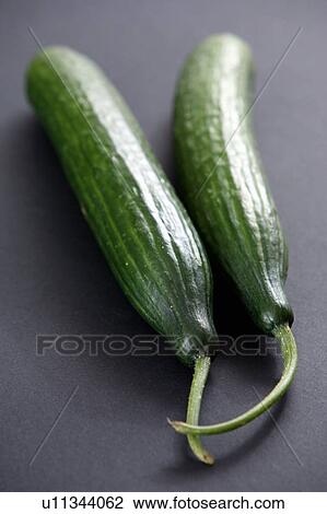 Stock Image - Cucumbers, black background. Fotosearch