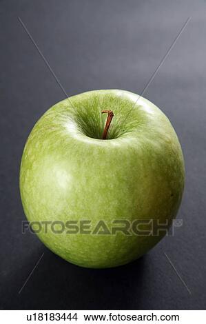 Picture - Granny Smith apple, black background. Fotosearch