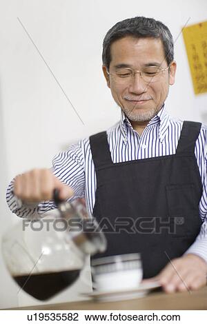 A Mature Adult Man Pouring Coffee into a Cup, Low Angle View, Differential Focus View Large Photo Image Stock Image - A Mature Adult Man Pouring Coffee into a Cup, Low Angle View, Differential Focus. Fotosearch