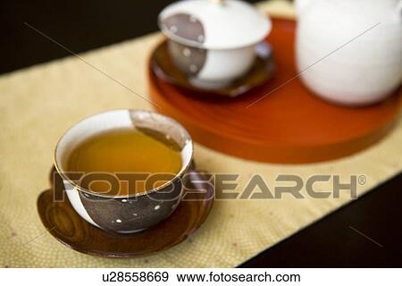 Tea pot and two cups of green tea on table, high angle view, close up, black background, Japan View Large Photo Image Stock Photo - Tea pot and two cups of green tea on table, high angle view, close up, black background, Japan. Fotosearch