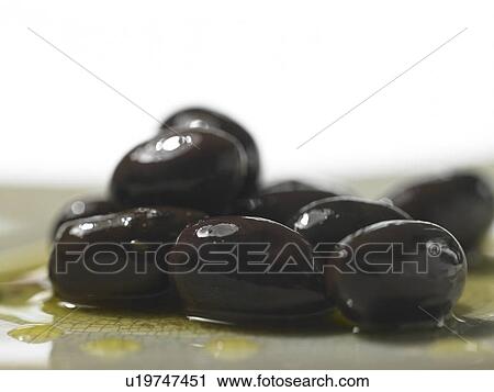 Stock Image - Wet Black Olives in a pile. Fotosearch