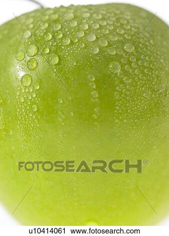 Stock Image - One green apple with dew on it. Fotosearch