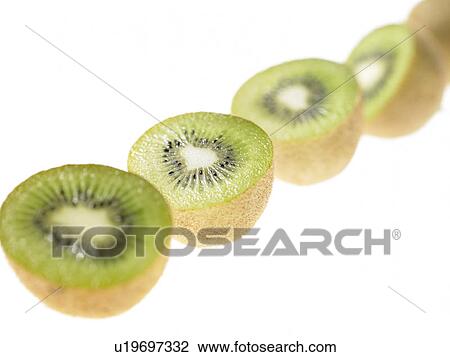 Stock Image - Row of Kiwi Fruit cut in half. Fotosearch