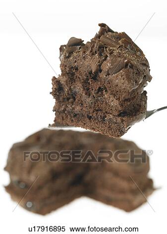 Stock Photography - One chocolate cake with a slice being taken. Fotosearch