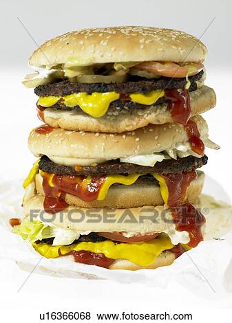 Three beef burgers with toppings View Large Photo Image Stock Photo - Three beef burgers with toppings. Fotosearch