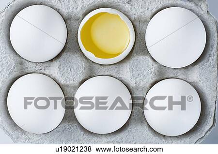 Stock Photo - Close-up of a broken egg in an egg carton. Fotosearch