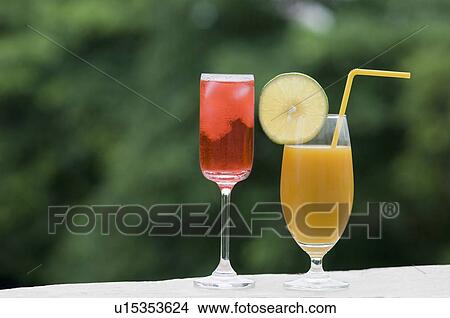 Close-up of a glass of cocktail and a glass of juice View Large Photo Image Picture - Close-up of a glass of cocktail and a glass of juice. Fotosearch