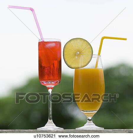 Stock Image - Close-up of a glass of cocktail and a glass of juice. Fotosearch
