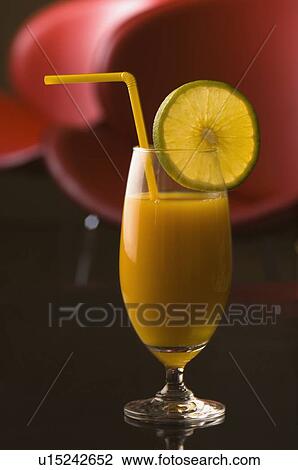 Stock Image - Close-up of a glass of orange juice with a lemon slice. Fotosearch