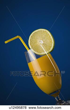 Stock Photo - Close-up of a glass of orange juice with a lemon slice. Fotosearch