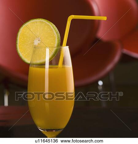 Stock Photograph - Close-up of a glass of orange juice with a lemon slice. Fotosearch