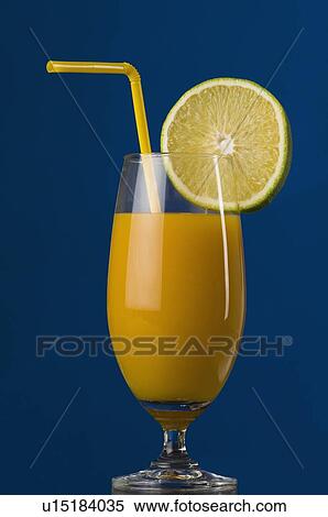 Stock Photography - Close-up of a glass of orange juice with a lemon slice. Fotosearch
