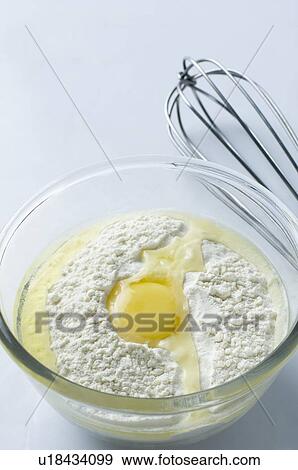Stock Photo - Close-up of an egg yolk with flour in a glass bowl. Fotosearch