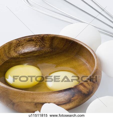 Stock Photography - Close-up of egg yolks in a wooden bowl. Fotosearch