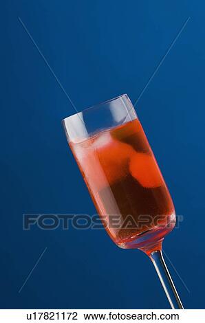 Stock Image - Close-up of ice cubes in a glass of cocktail. Fotosearch