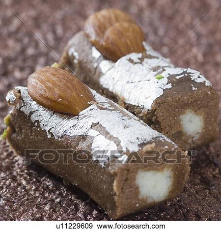 Stock Photo - Close-up of a chocolate roll garnished with Almonds. Fotosearch
