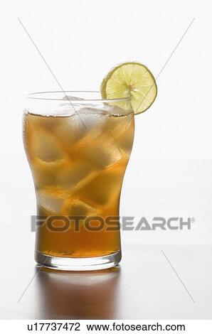 Stock Image - Close-up of a glass of lemonade with ice cubes and a slice of lemon. Fotosearch