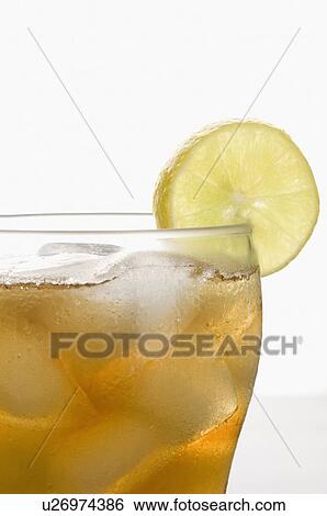 Stock Photograph - Close-up of a glass of lemonade with ice cubes and a slice of lemon. Fotosearch