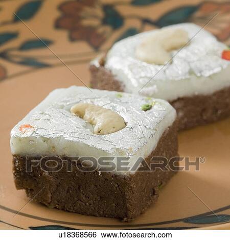 Stock Photograph - Close-up of chocolate Burfi garnished with Cashew nuts. Fotosearch