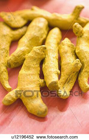 Stock Image - Close-up of dry turmeric in a tray. Fotosearch