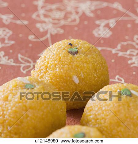Stock Image - Close-up of four Ladoos. Fotosearch