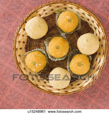 Stock Image - High angle view of Ladoos in a basket. Fotosearch