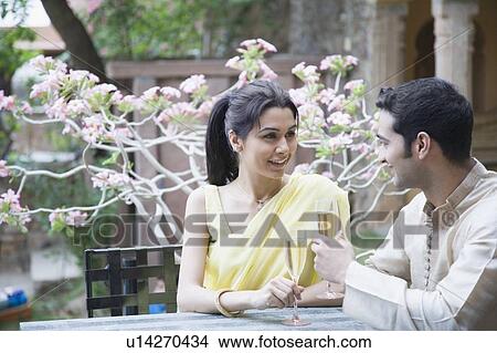 Picture - Close-up of a young couple holding champagne flutes and smiling. Fotosearch