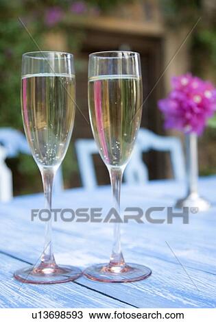 Close-up of two champagne flutes on a table View Large Photo Image Stock Image - Close-up of two champagne flutes on a table. Fotosearch