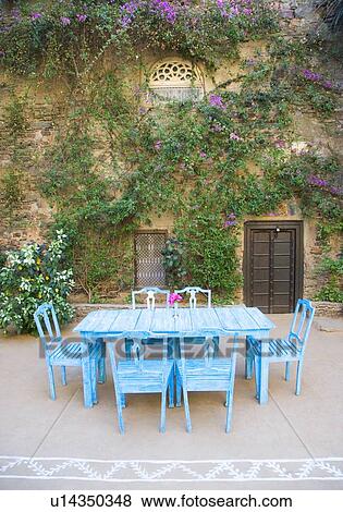 Stock Photo - Dining table and chairs out side a house. Fotosearch
