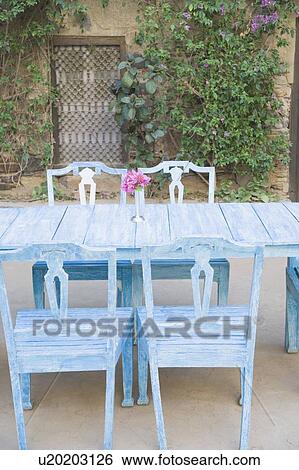 Stock Photograph - Dining table and chairs out side a house. Fotosearch