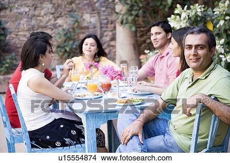 Picture - Group of people sitting at a dining table. Fotosearch