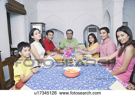 Group of people sitting at a dining table View Large Photo Image Stock Photograph - Group of people sitting at a dining table. Fotosearch