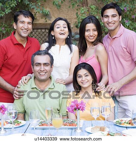Portrait of a group of people at a dining table and smiling View Large Photo Image Stock Photo - Portrait of a group of people at a dining table and smiling. Fotosearch